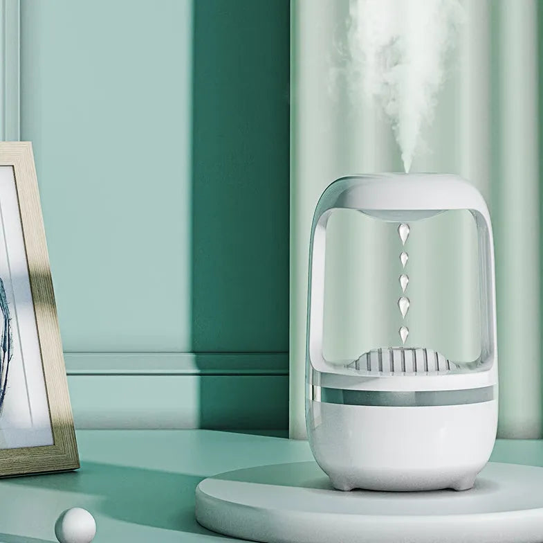 Black or white anti-gravity humidifier with water droplet effect on a desk.