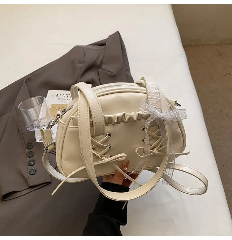 Milky white women's PU shoulder bag with a black bandage bow and sewing thread detail.