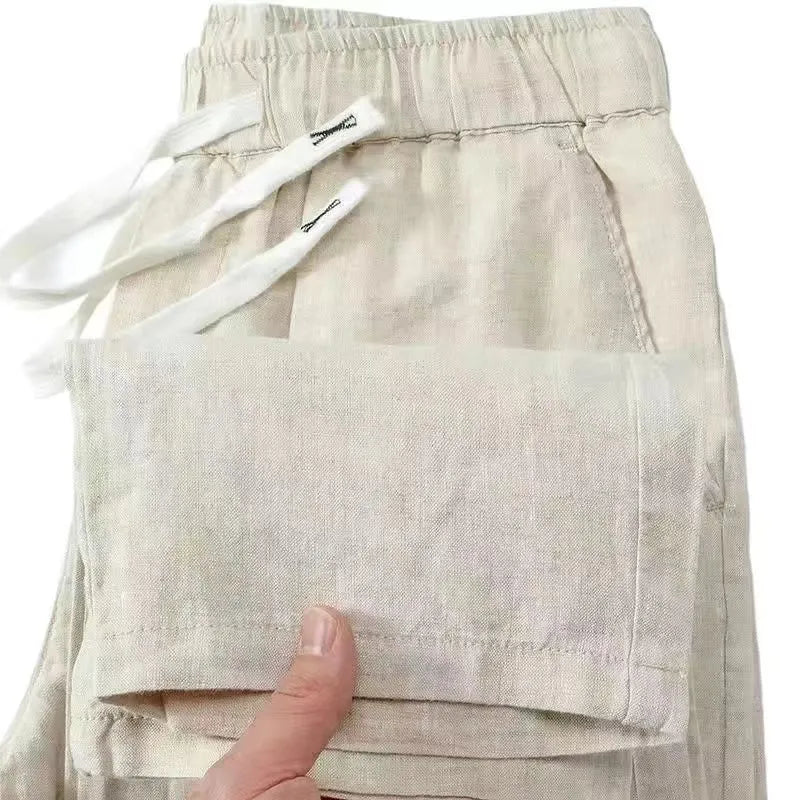 Man wearing apricot-coloured straight leg linen trousers with a drawstring waist.