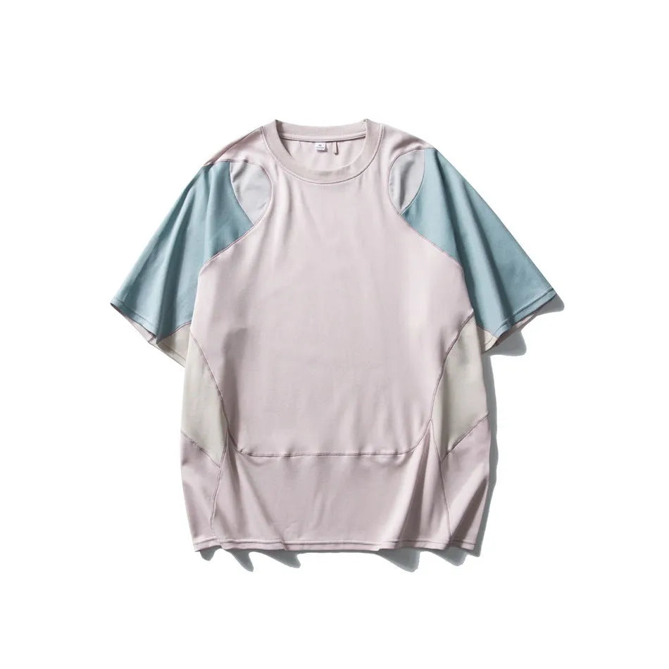 Man wearing a loose fit patchwork t-shirt in a solid colour with short raglan sleeves.