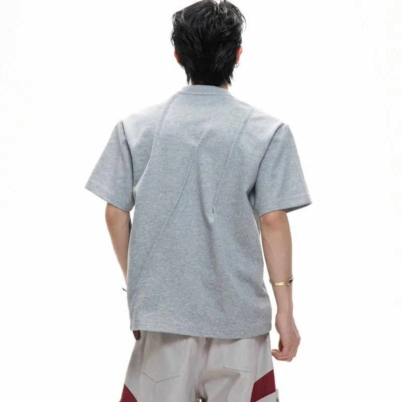 Men's grey cotton T-shirt with loose fit, round neck, short sleeves, and textured three-dimensional pleats.