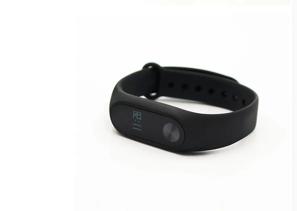Xiaomi Mi Band 2 black smartband on wrist showing OLED display with heart rate and step count.