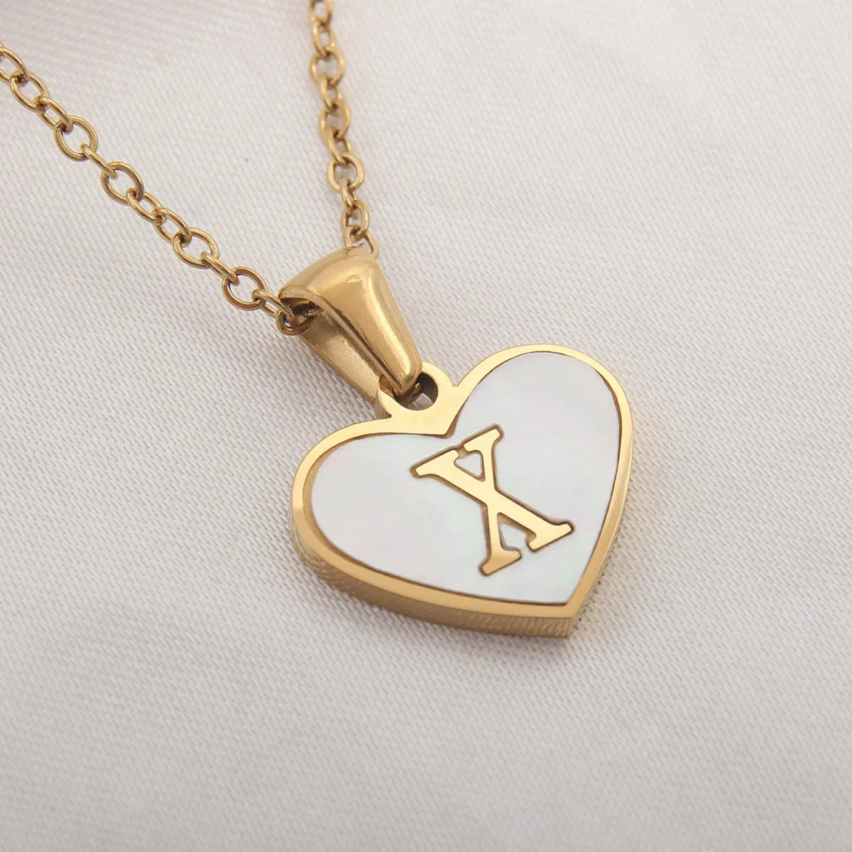 Gold plated heart-shaped personalised necklace with white shell charm on an adjustable chain.