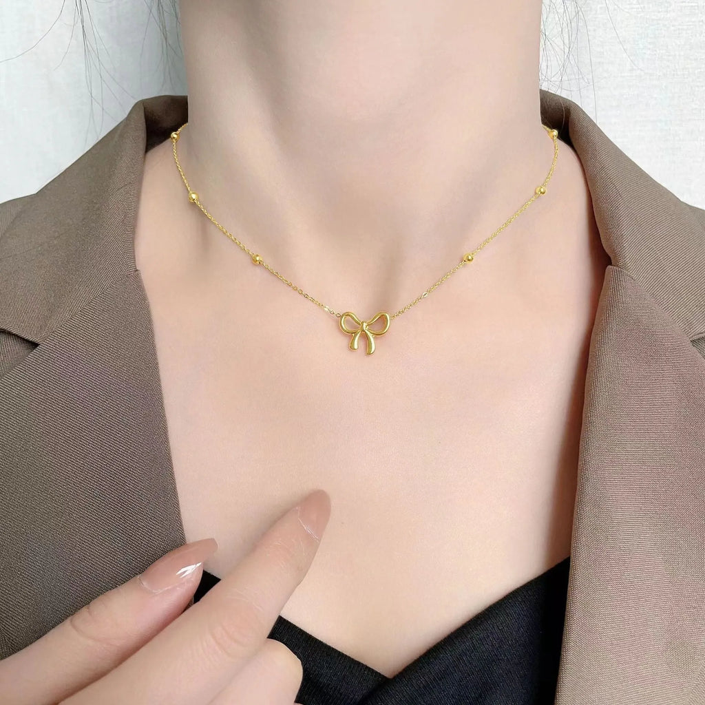 Gold electroplated titanium steel women's necklace with bow pendant and adjustable cross chain