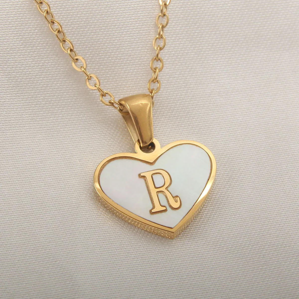 Gold plated heart-shaped personalised necklace with white shell charm on an adjustable chain.