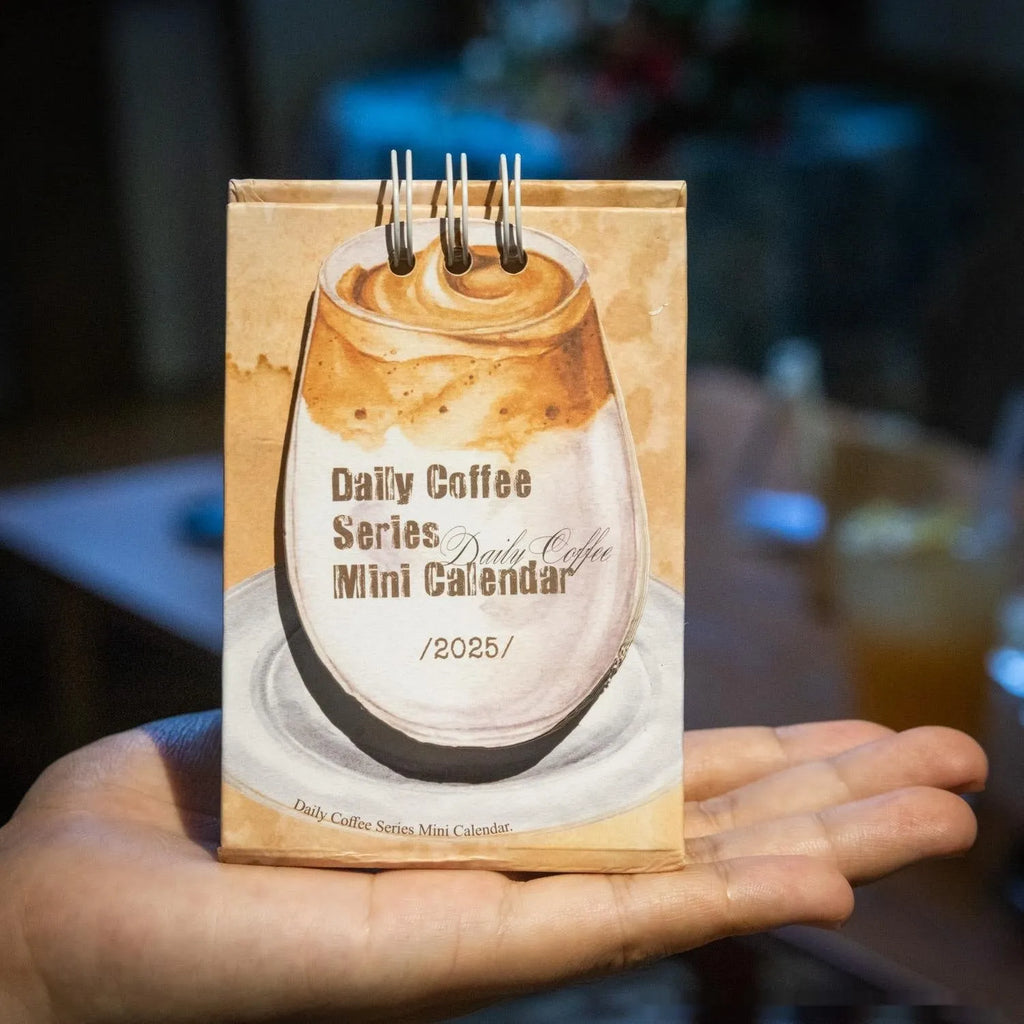 Mini A6 paper desk calendar for 2025 open to a monthly page with coffee-themed design.