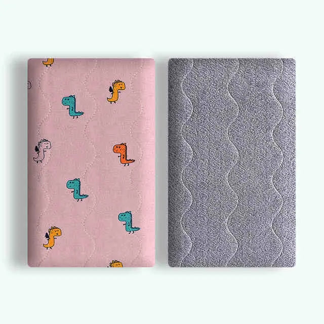 A soft cotton velvet pet blanket with a colourful dinosaur print, shown folded next to a dog bed.