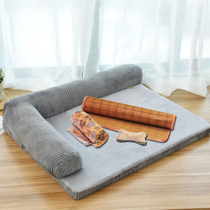 A corduroy pet sofa dog bed with a raised bolster, shown in a grey colour on a wooden floor.