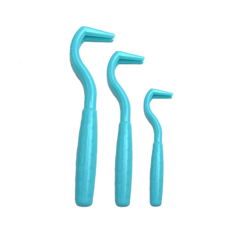 Set of three coloured tick hook removers for dogs on a white background.