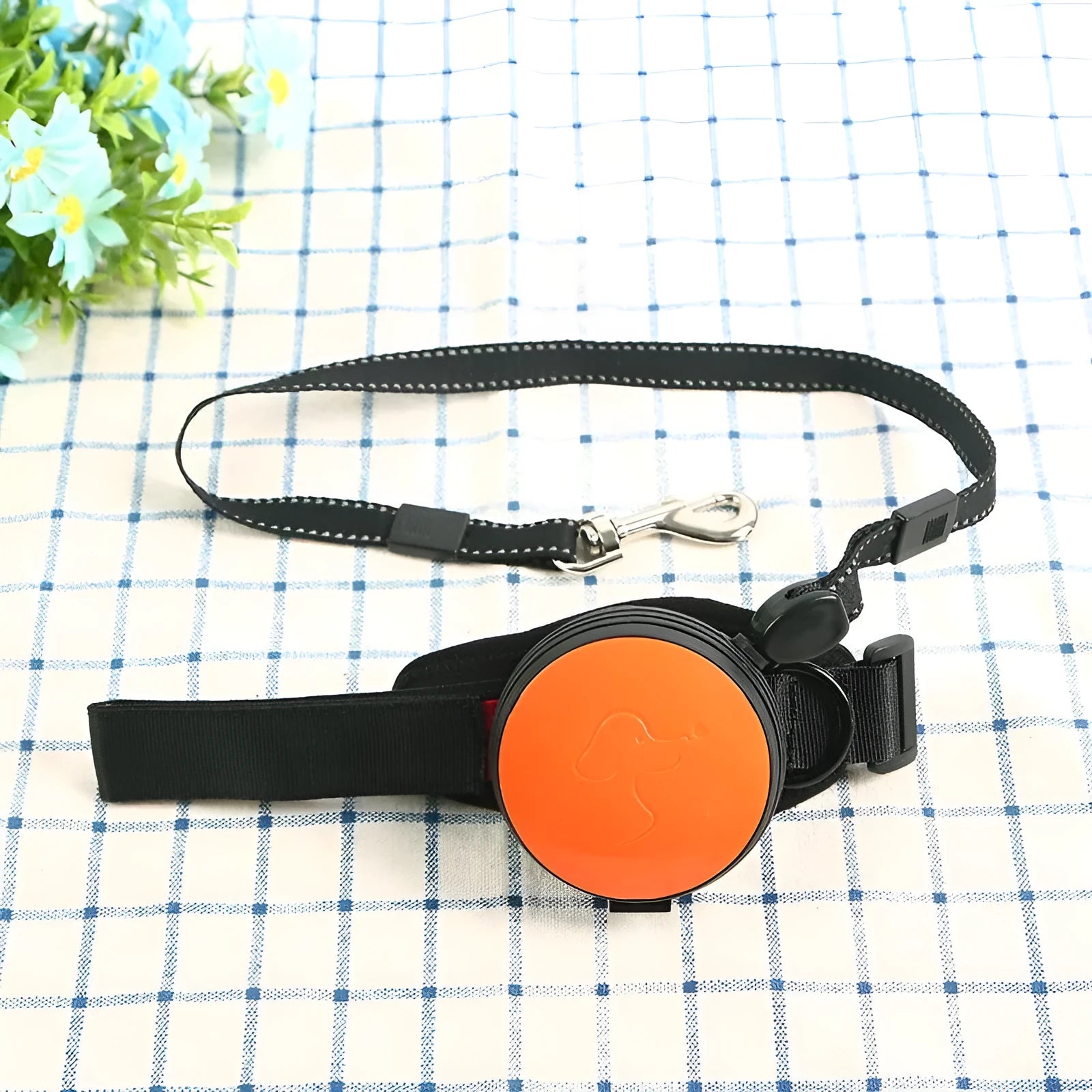 Retractable dog leash with extended nylon cord in vibrant orange colour, showing handle and explosion-proof design.