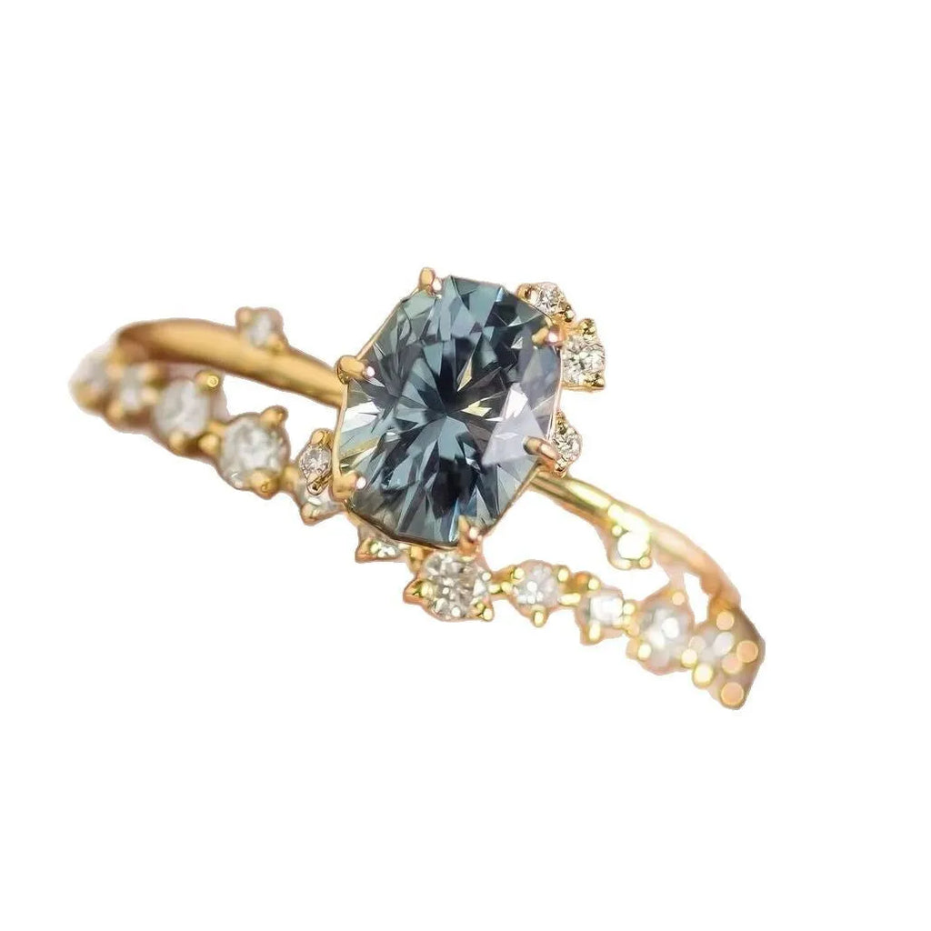 Gold electroplated floral-shaped alloy ring with a green zircon inlay on a white background.