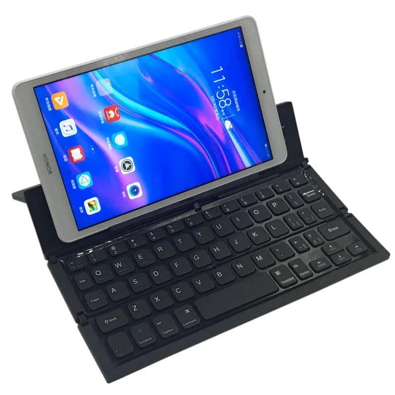 Black folding Bluetooth wireless keyboard next to tablet showing compact portable design
