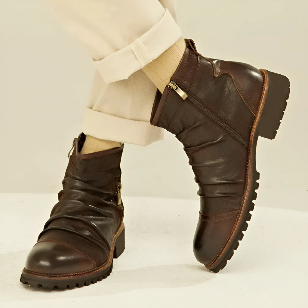 Brown mid-calf cowboy boots with side zipper, round toe, and horseshoe heel on wooden floor