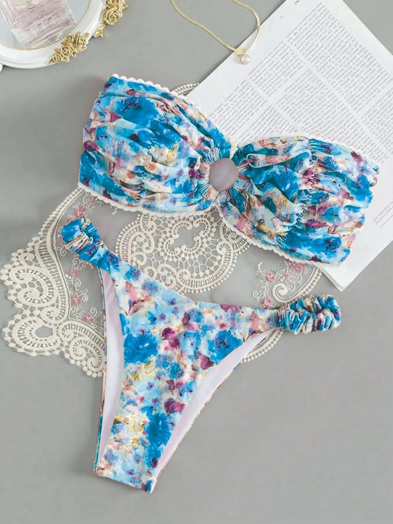 Blue floral print tube top bikini set with lace trim on a mannequin.