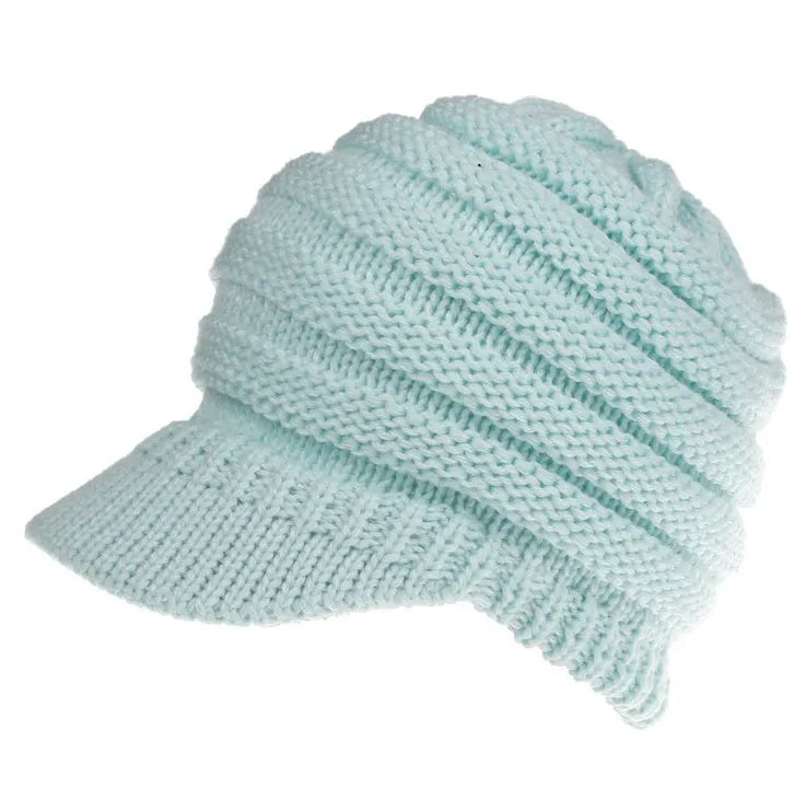 Woman wearing a soft knitted beanie with a ponytail pulled through the hole at the back.