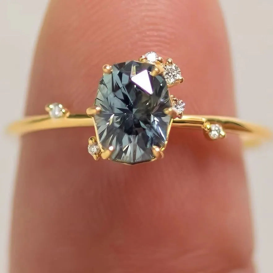 Gold electroplated floral-shaped alloy ring with a green zircon inlay on a white background.
