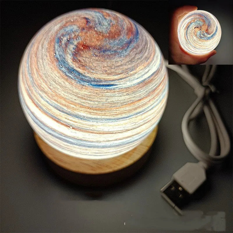 Compact modern planet USB night light on its base with dimmable three-colour lighting.