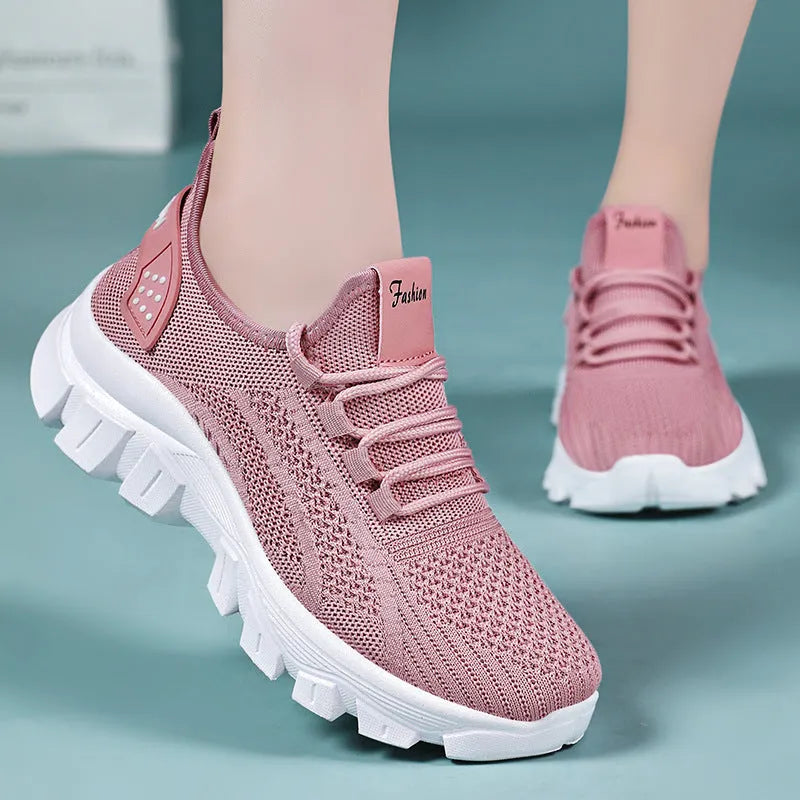 Women's white Flyknit sneaker with thick sole and lace-up front, shown on a neutral background