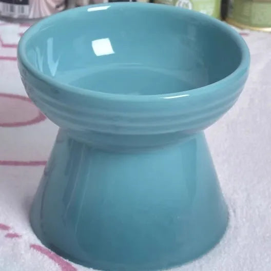Black ceramic pet bowl with a raised foot and high neck guard for dogs and cats.
