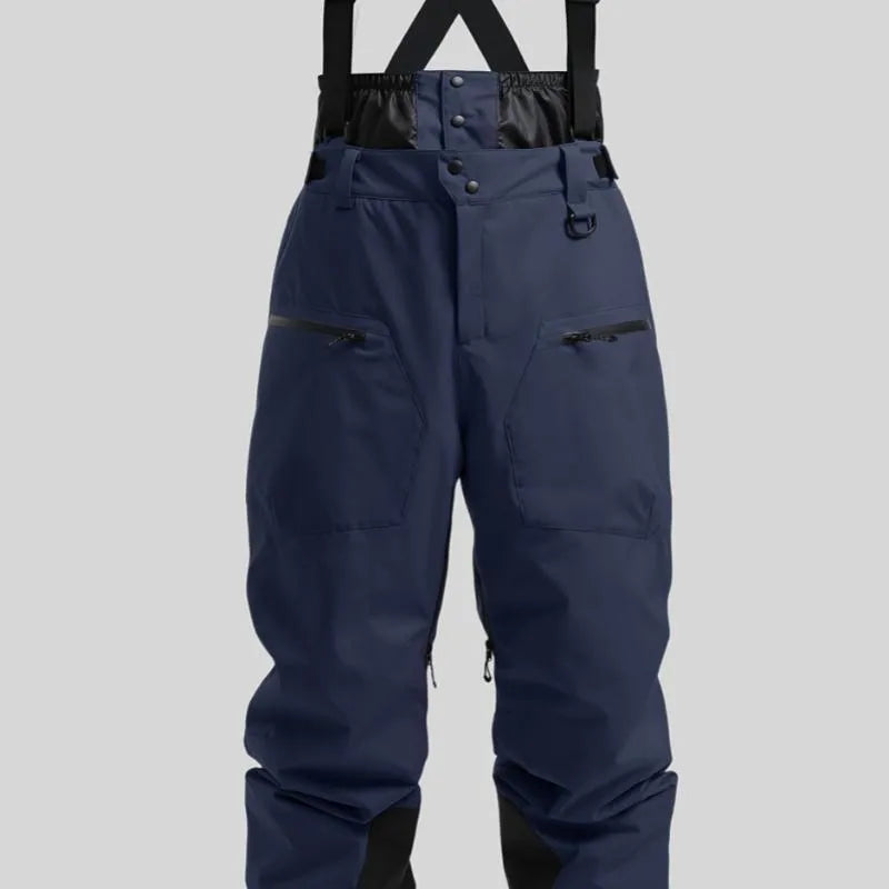 Man wearing black waterproof ski trousers with an adjustable strap on a snowy slope.
