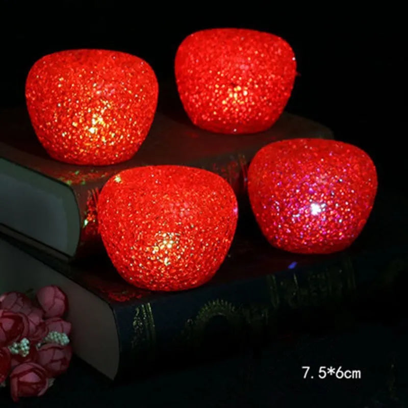 LED lit crystal apple Christmas decoration with warm glow on a shelf