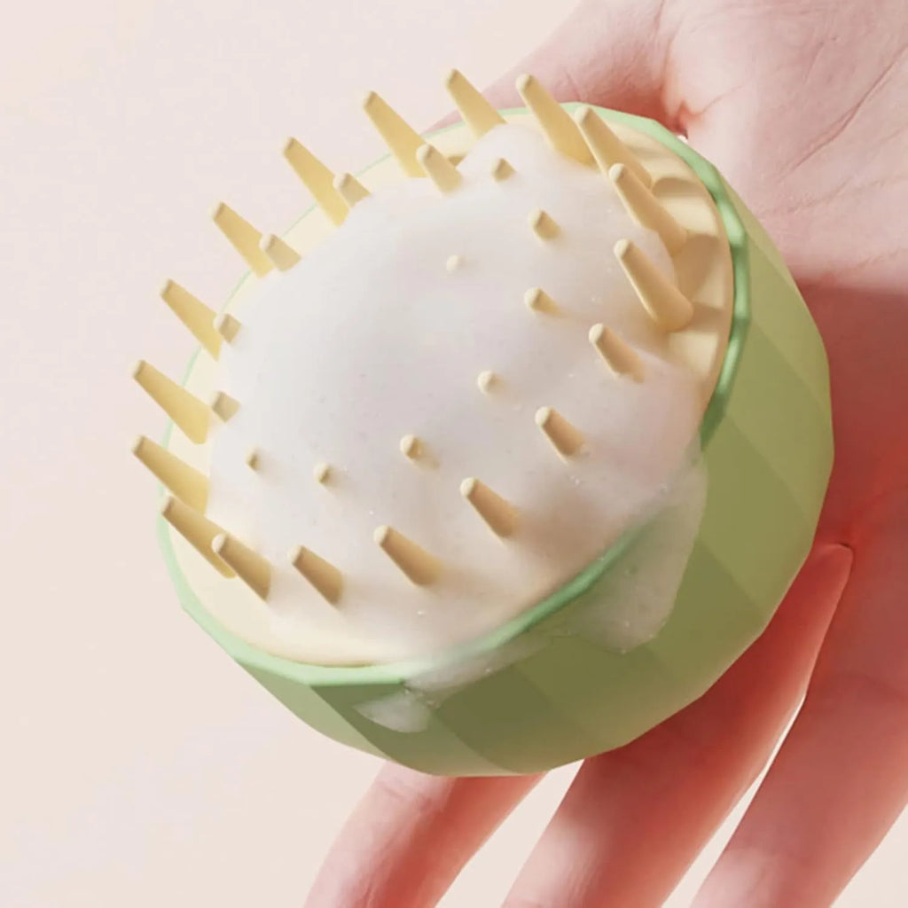 Green double-sided pet bath massage brush with silicone bristles and drain holes.