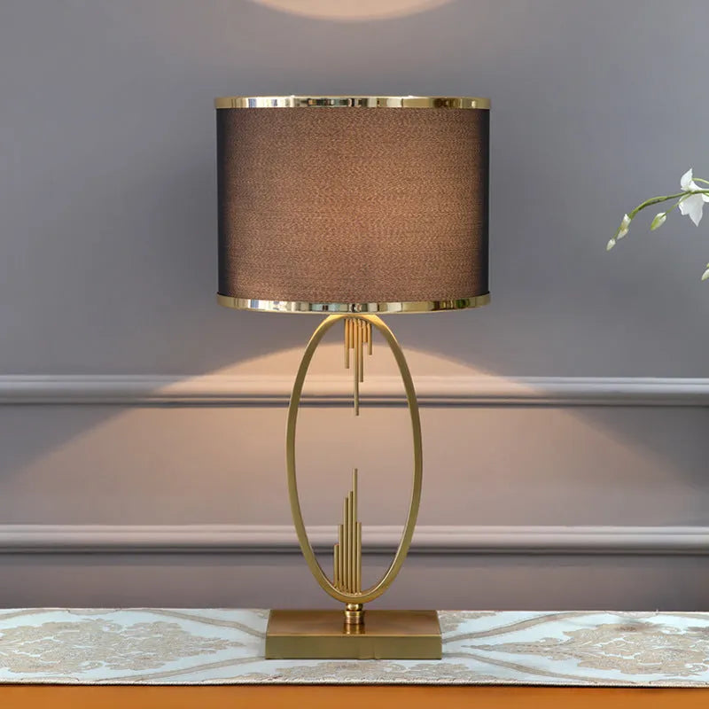 White Nordic style bedside lamp with drum shape and Phnom Penh trumpet design on a wooden table