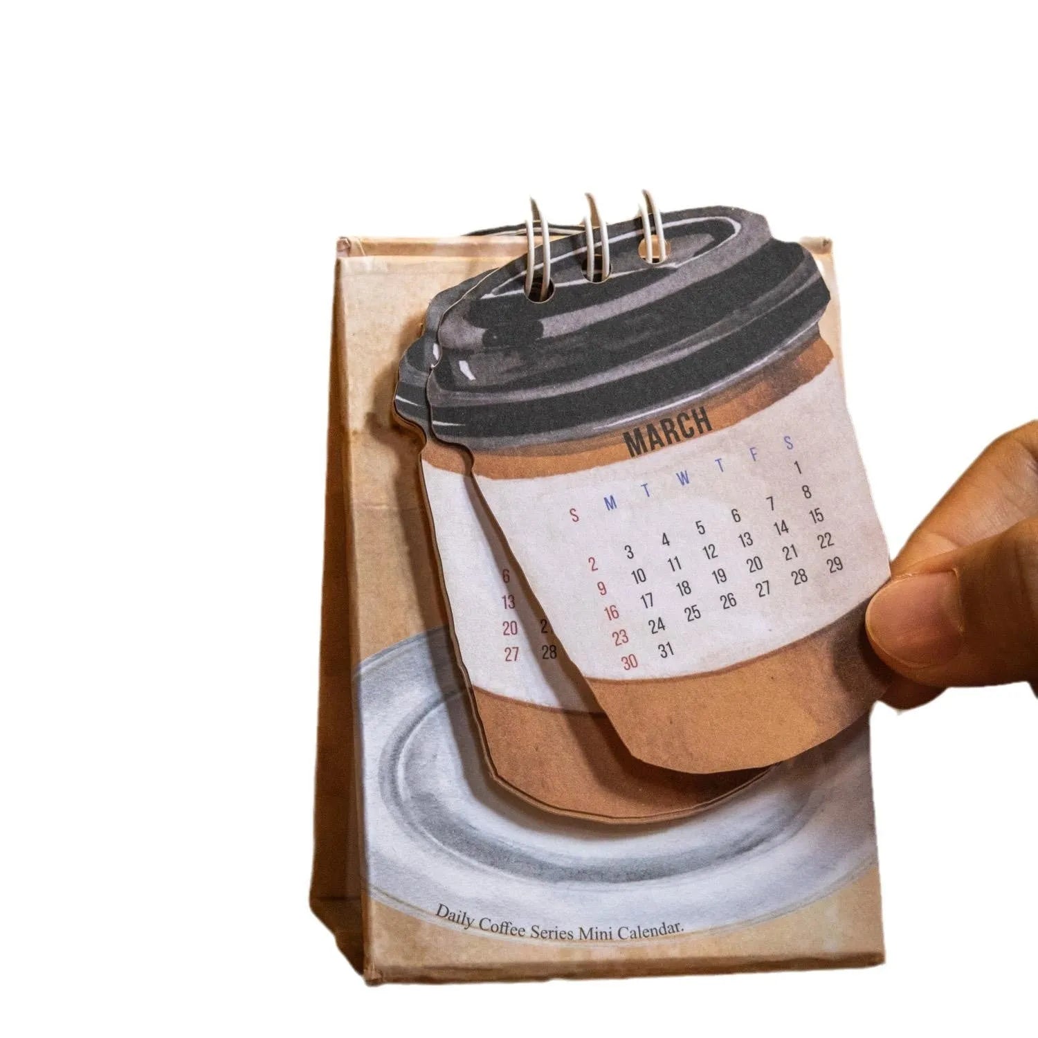 Mini A6 paper desk calendar for 2025 open to a monthly page with coffee-themed design.