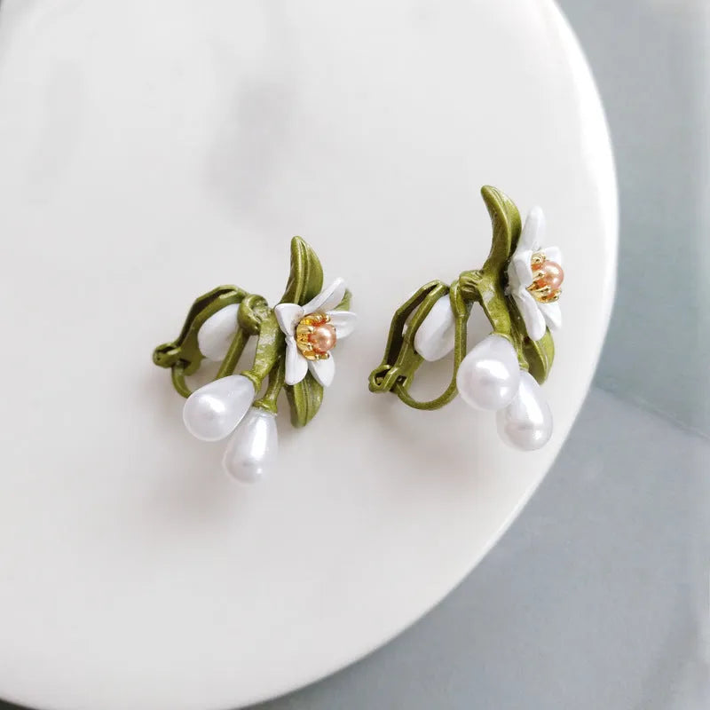 Alloy camellia flower earrings with sterling silver needle and contrasting colours including stud and clip options