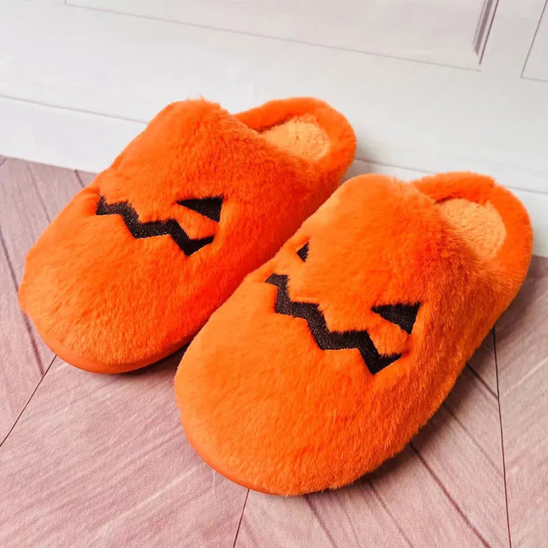 Orange Halloween pumpkin themed slippers with coral velvet upper and plush lining on a flat PVC sole.