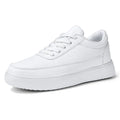 Women's white leather lace-up casual flat trainers on a plain background.