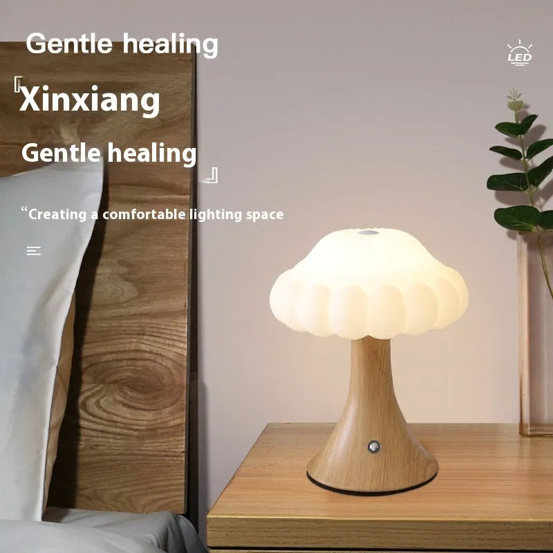 Small touch control rechargeable mushroom night light in wood grain colour on a table.
