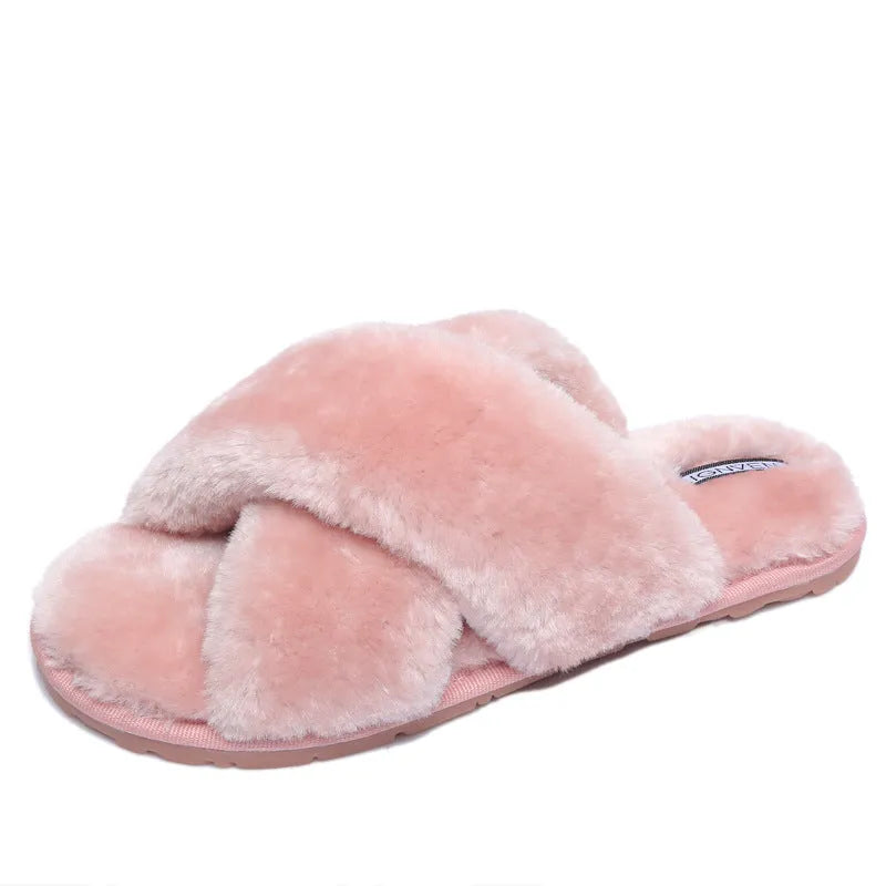 Women's black cross open-toe fur slippers with a patterned non-slip sole on a wooden floor
