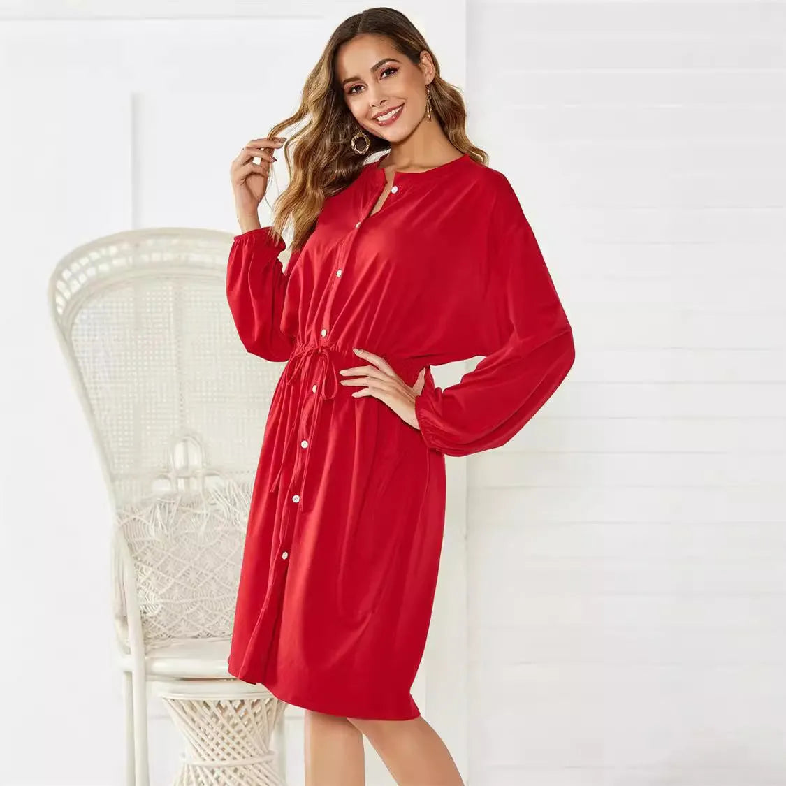Women's black A-line midi dress with cinched waist belt and long sleeves on hanger
