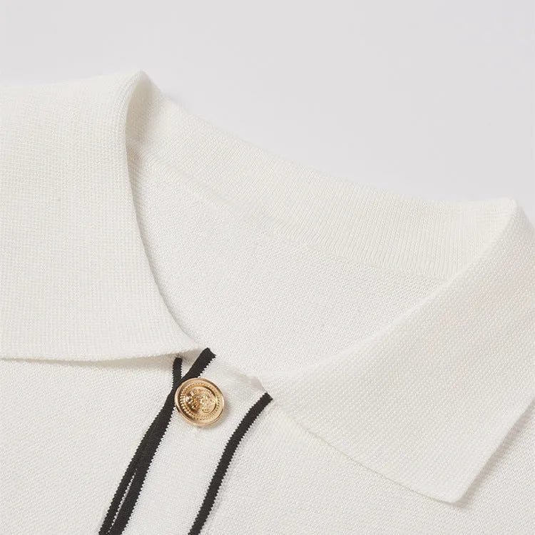 White short-sleeved cardigan with dark contrast lapels laid flat.