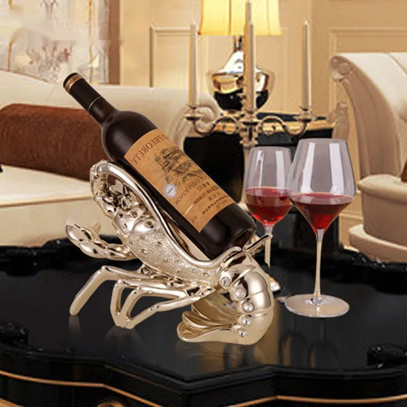 Rose gold resin lobster ornament holding a wine bottle on a wooden shelf.