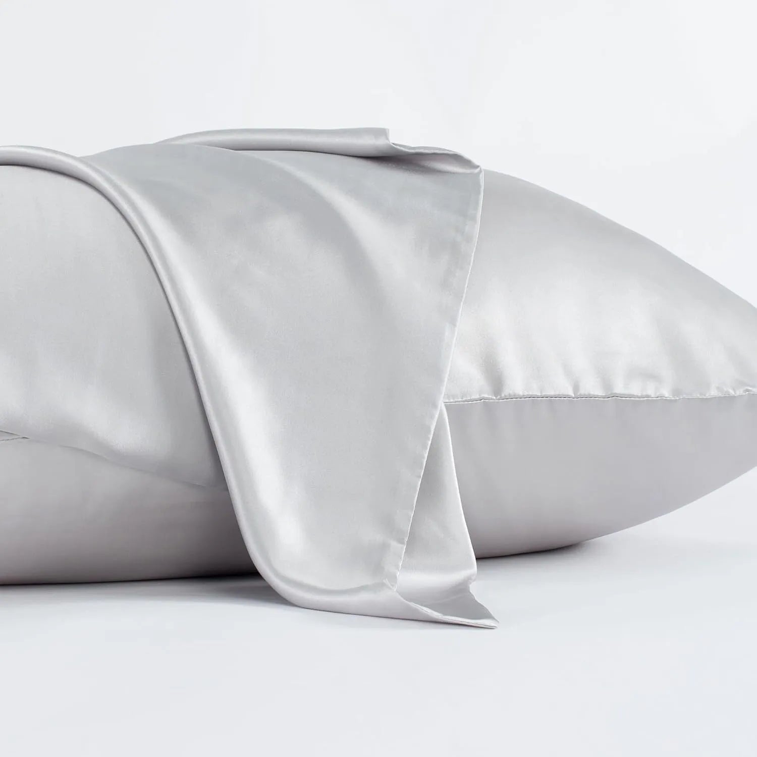 Dark grey mulberry silk pillowcase with an envelope closure on a bed.