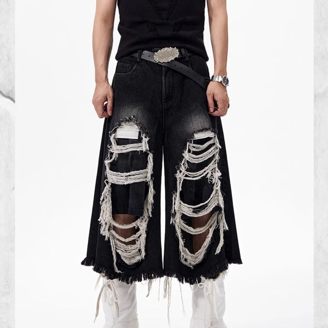 Black cropped wide-leg jeans with ripped patch detail on the leg, showing a mid-high waist and loose fit.