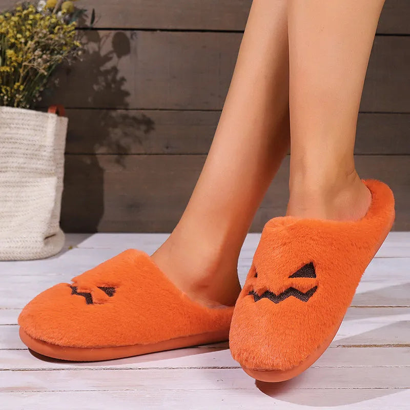 Orange Halloween pumpkin themed slippers with coral velvet upper and plush lining on a flat PVC sole.