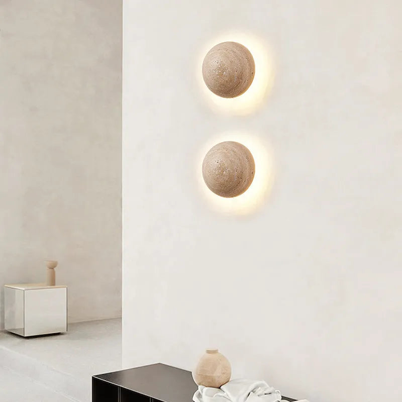 Vintage semicircle wall lamp with yellow cave stone shade and black iron frame mounted on a wall.