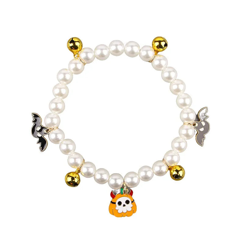 Adjustable simulated pearl necklace cat collar with a Halloween pumpkin charm in purple ghost, skull, or smile designs.