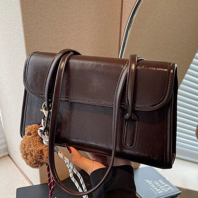 Brown women's PU leather shoulder bag with square shape, pendant detail, and double shoulder straps