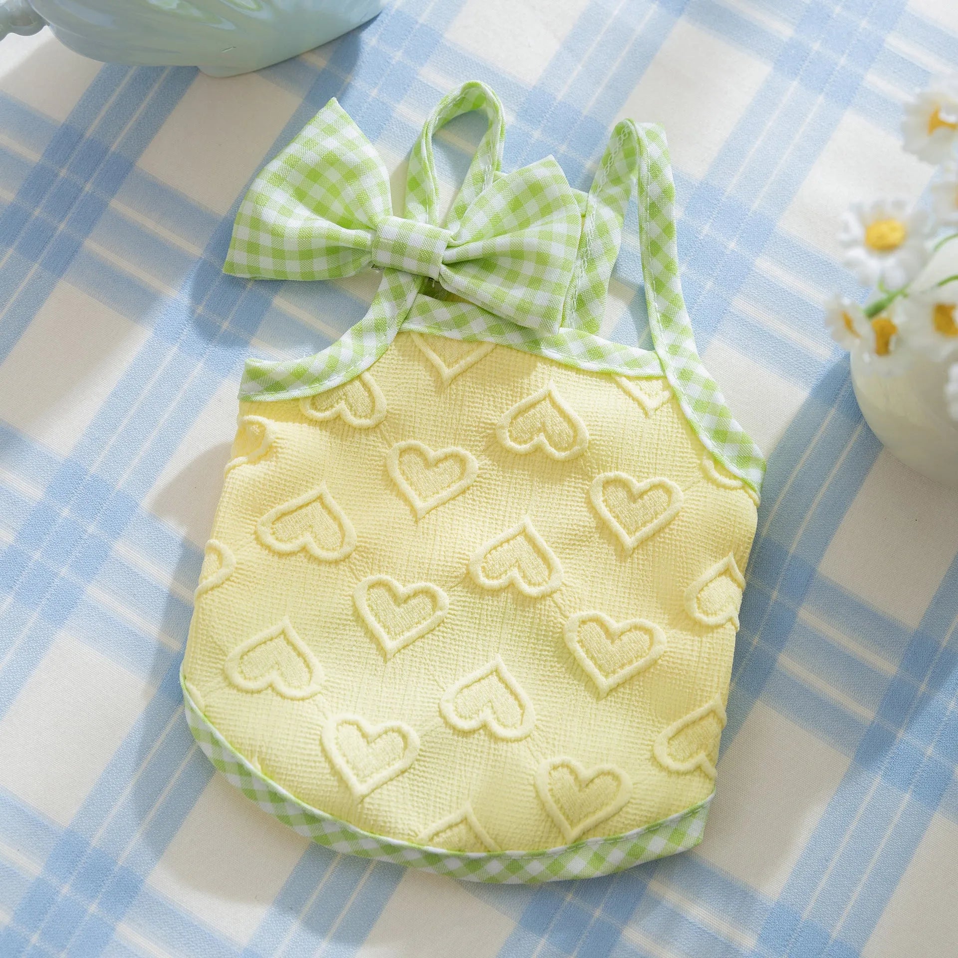 Small dog wearing heart pattern vest with bow suspenders in blue colour, showing elastic fit and decorative design
