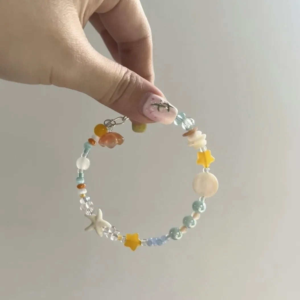 Orange sea coloured mixed material summer bracelet with diamond shape and round elements