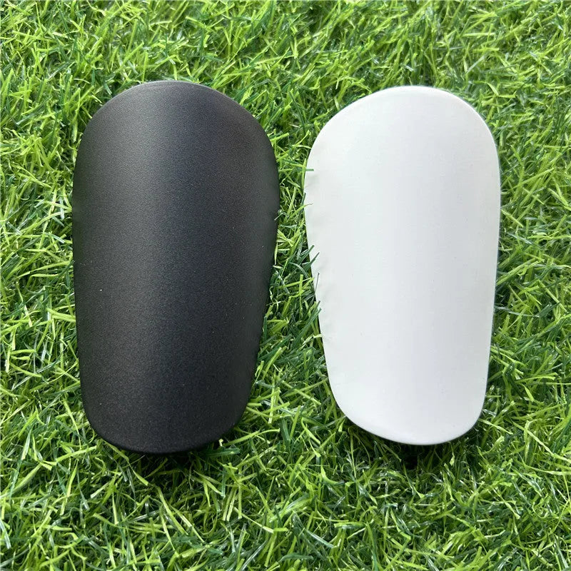 Extra small 8x5cm plastic football shin guards in black and white colours
