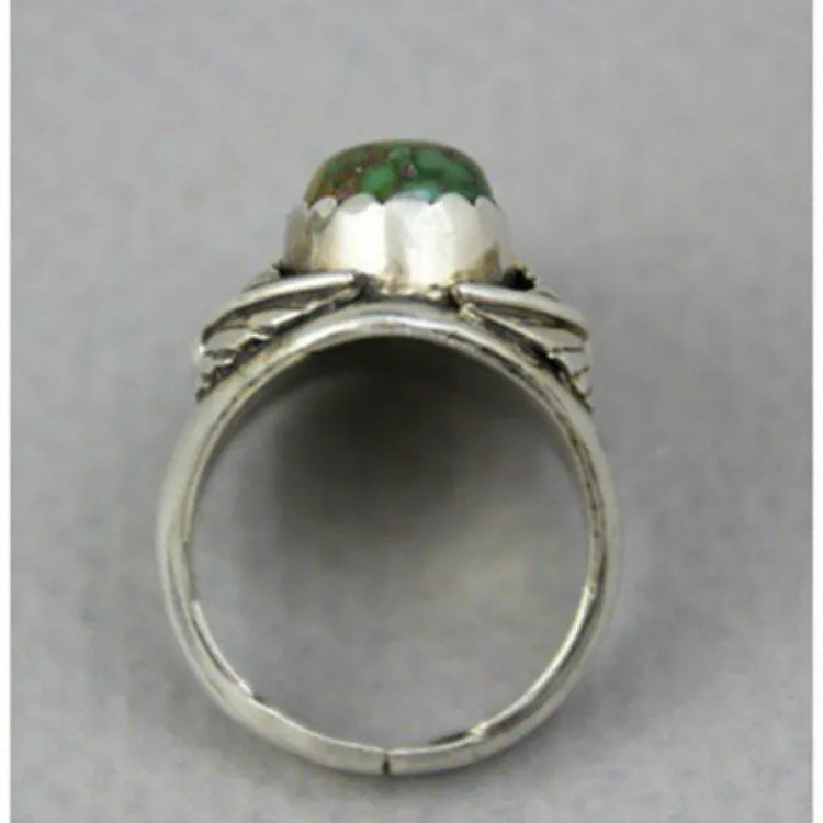 Silver-toned geometric women's ring with a turquoise stone inlay, shown on a finger.