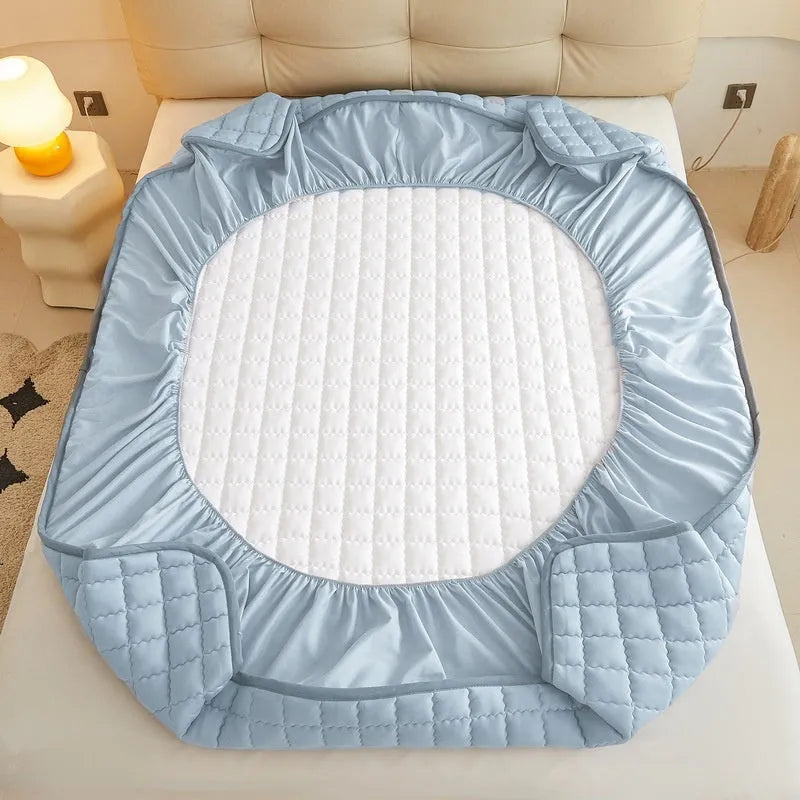 A washed cotton waterproof fitted sheet in a neutral colour, shown fitted neatly on a mattress corner.