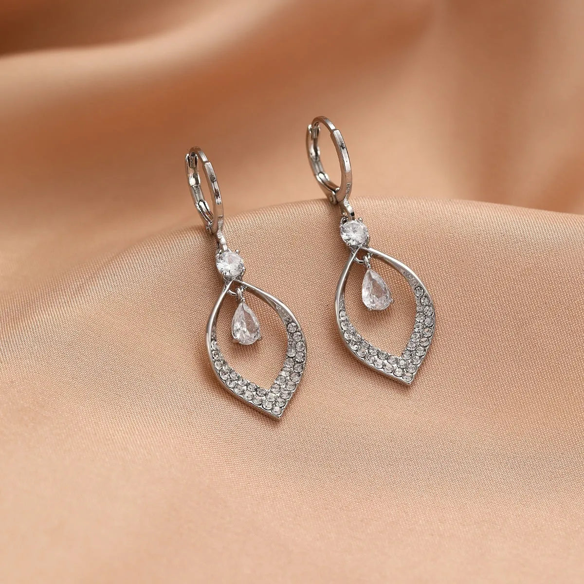 Copper electroplated women's earrings with a teardrop shape, water drop tassels, and zircon stones in gold colour.