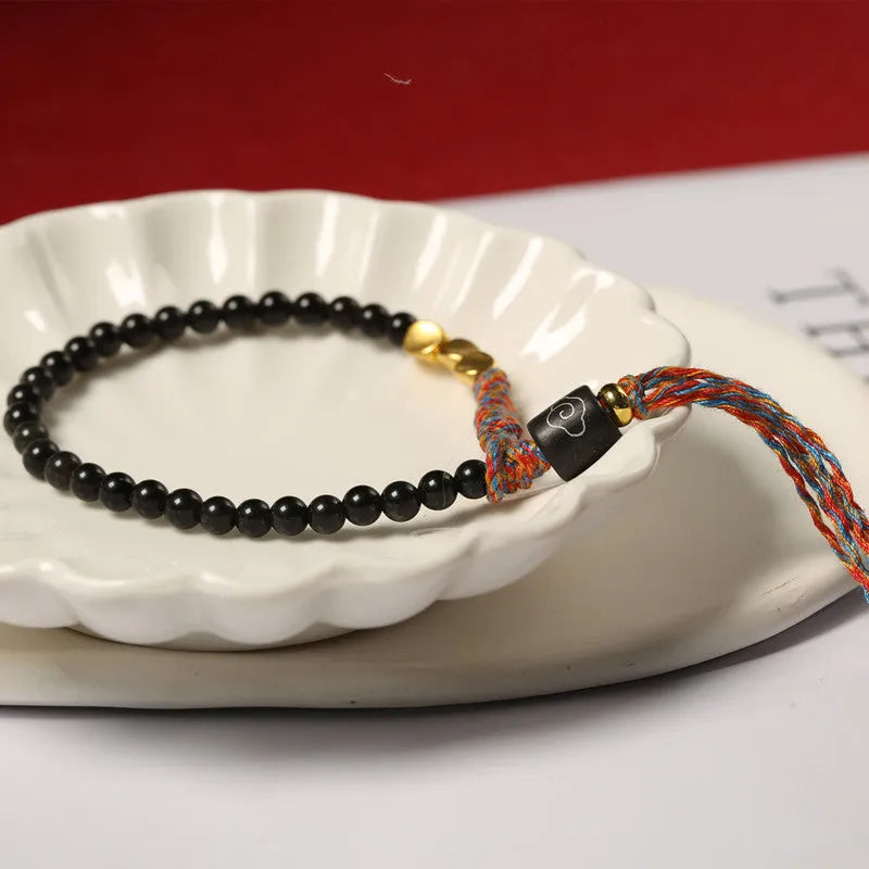 Hand-woven obsidian carrying strap bracelet showing braided detail and adjustable 15.5-16cm length