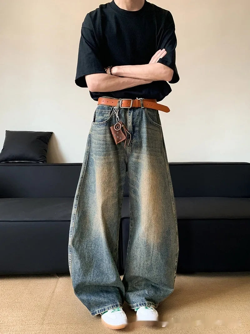 Man wearing retro blue distressed denim jeans with a slim-fit wide-leg cut.